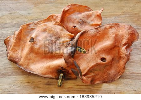 dog snack dried ear cow with loop on wooden board