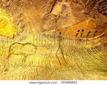 Buffalo Hunting. Paint Of Human Hunting On Sandstone Wall, Prehistoric Picture. Black Carbon Abstrac