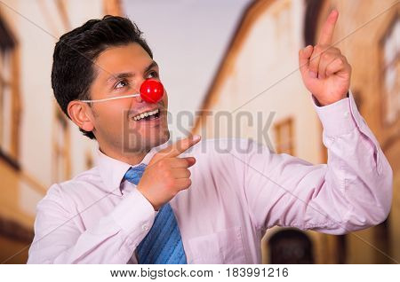 Funny handsome businessman with red plastic nose.