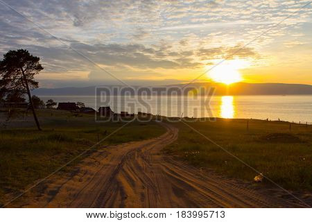 Sunset on the island of Olkhon on Lake Baikal. Shoot on sandy road