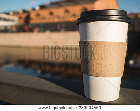 Takeaway Paper Coffee Cup With Emptu Blank Standing On Railing On Urban Background