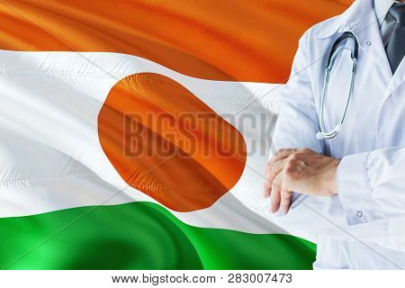 Nigerien Doctor Standing With Stethoscope On Niger Flag Background. National Healthcare System Conce