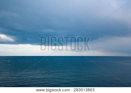Dramatic Seascape With Grey Cloudy Sky And Boat In Distance