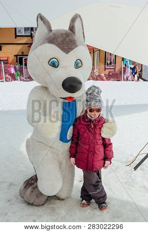 Sheregesh, Kemerovo Region - April 6, 2018. U-laika Symbol Of Universiade 2019 Hugging A Little Girl