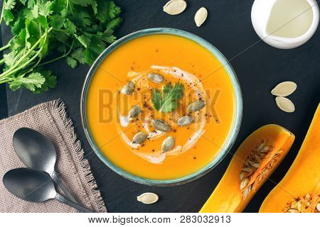 Butternut Squash Or Pumpkin Soup In A Bowl. Ingredients, Cream, Cilantro, Pumpkin Slices And Seeds O