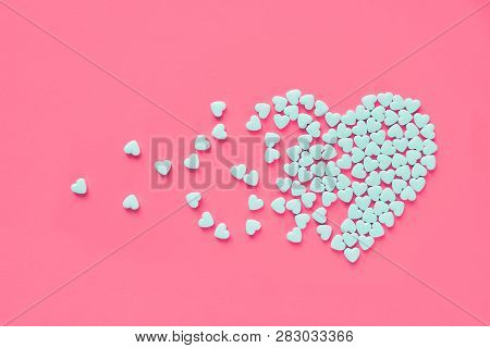 White Heart Shaped Candies On A Pink Paper Background. Broken Heart Or Pearts Gethering Love Concept