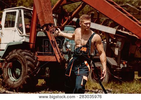 Power Concept. Power Man Pull Tractor With Crane. Power Lifter At Construction Site. Feel The Power.