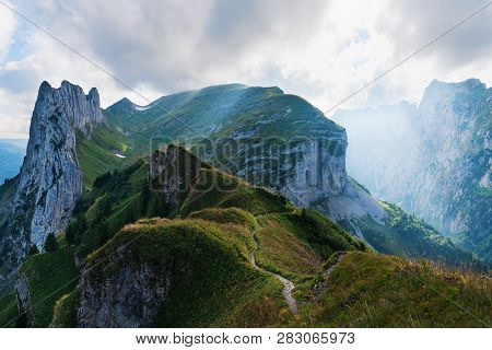 Mountain Landscape In The Swiss Alps With Jagged Peaks And A Pristine Blue Mountain Lake In The Vall