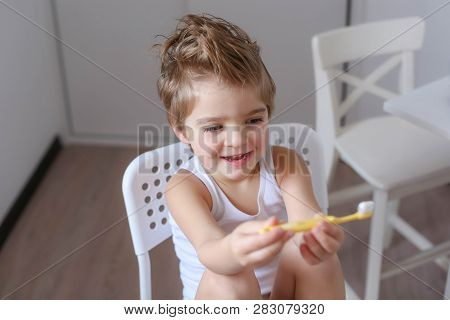 Boy Cleans His Teeth In The Morning And Plays With A Toothbrush.