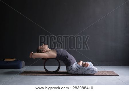 Woman Practicing Yoga In Lotus Fish Posture Matsyasana