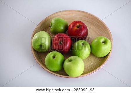 Green And Red Apple Lies On A White Table