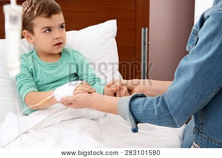 Woman Visiting Her Little Child With Intravenous Drip In Hospital