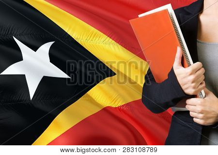 Learning Timorese Language Concept. Young Woman Standing With The East Timor Flag In The Background.