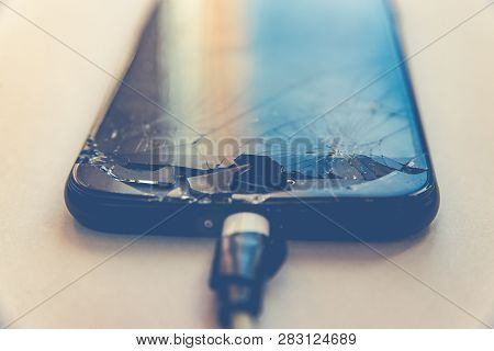 Cell Phone With The Screen Broken By A Hammer. Non-warranty Repairs Concept.