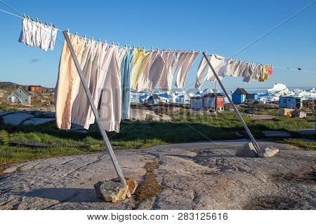 Roskilde, Denmark - July 9, 2018: A Clothes Line With Colorful Houses And Icebergs In The Background