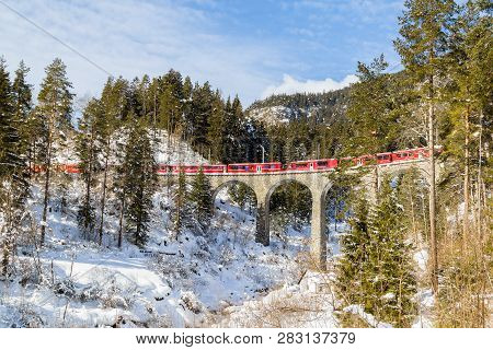 Schmitten, Switzerland - January 19. 2019: A Red Passenger Swiss Train Passing On The Schmitten Viad