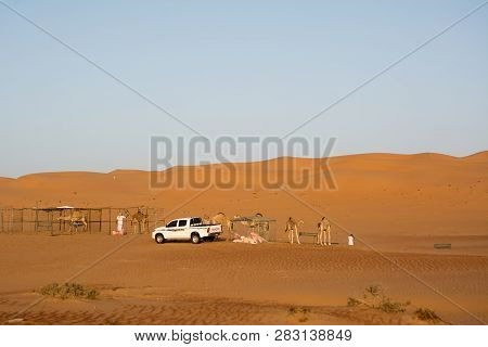 Bidiyah, Oman - November 5, 2018: Fence For Domedarians And Car Pickups Under Desert Dunes Wahiba Sa