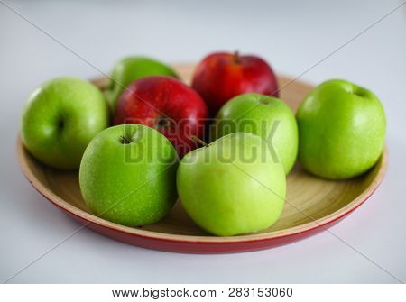 Green And Red Apple Lies On A White Table