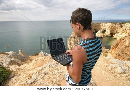 mand, der arbejder med laptop på kysten