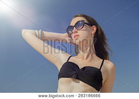 Beautiful Young Woman In Swimsuit Under Sun Rays Tanning, Toned Image