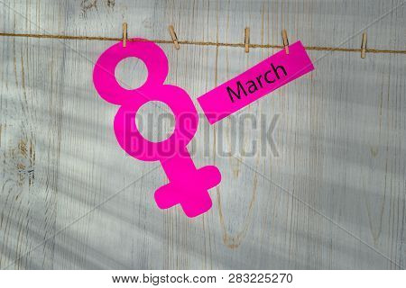 Womens Day Concept. The Symbol Of Venus, The Feminine. Pined On The Clothespins Paper Figure Eight A