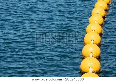 String Of Buoys Floating On Ocean Surface
