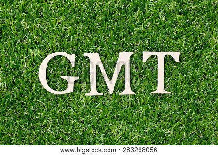Wood Letter Block In Word Gmt (abbreviation Of Greenwich Mean Time) On Artificial Green Grass Backgr