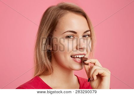 Close Up Of Attractive Girl Eats Delicious Dessert, Looks Mysteriously At Camera, Enjoys Sweet Choco