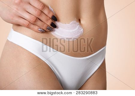 Cropped Image Of Unrecognizable Woman Applies Nourishing Cream On Belly, Uses Body Lotion, Dressed I