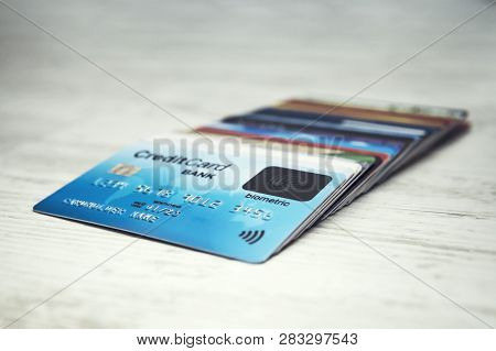 Close Up Of A Stack Of Credit Cards Lying In Order On The White Table Top. Many Different Credit Car