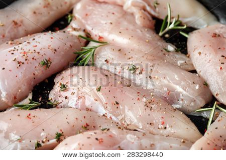 Raw Chicken Breast Mini Fillets In Rastic Cast Iron Skillet, Frying Pan With Herbs And Sea Salt