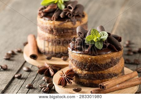 Dark Chocolate Cakes On Black Slattern Board With Mint, Cinnamon, Coffee Beans On A Wooden  Backgrou