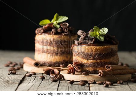 Dark Chocolate Cakes On Black Slattern Board With Mint, Cinnamon, Coffee Beans On A Wooden  Backgrou