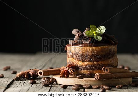 Dark Chocolate Cakes On Black Slattern Board With Mint, Cinnamon, Coffee Beans On A Wooden  Backgrou