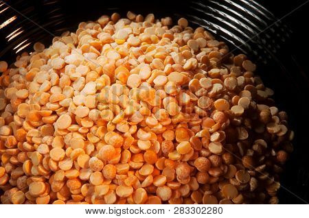Close Up Of Dry And Uncooked Yellow Split Peas In A Shiny Black Bowl