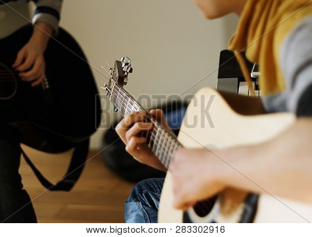The Musician Plays An Acoustic Guitar Beige, With A Friend