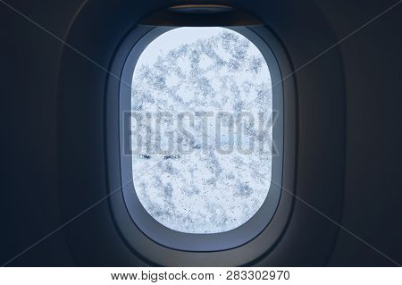 Snowing At The Airport. View From Window Of The Airplane Covered By Snow Before Deicing.