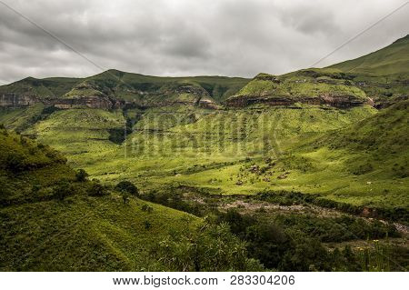 Cliffs And Hillsides Under A Dramatic Sky, Along The Tugela Gorge Hiking Route At The Base Of The Am