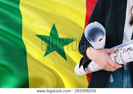 Senegalese Architect Woman Holding Blueprint Against Senegal Waving Flag Background. Construction An