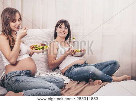 Maternity Concept, Two Pregnant Women Eating Fresh Salad At Home