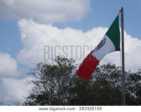 National Maxican Flag At Chichen Itza City Near Scenic Archaeological Site In Mexico With Trees And 