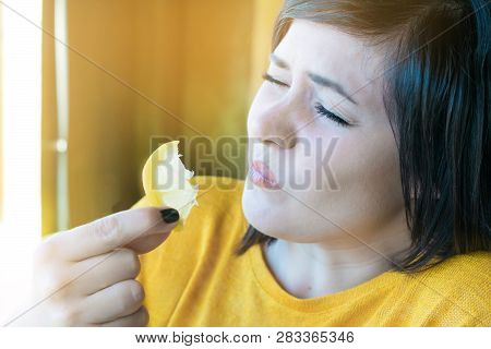 Beautiful Girl Eating Sour Lemon. Puckery From Sour