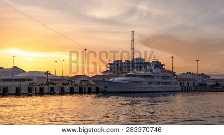 Three-deck Yacht In The Port, Illuminated By A Beautiful Orange Sunset Sun. Background With Copy Spa