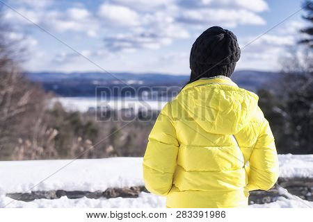 A Woman Wearing A Yellow Winter Jacket Looking Out Over The Landscape Of The Hills Around The Berksh