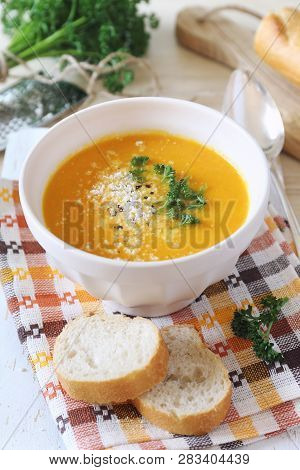 Vegetable Carrot Cream Soup With Parsley, Grated Cheese And Baguette