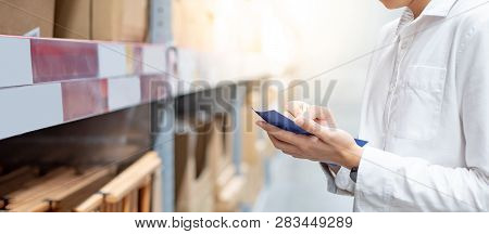Asian Guy Shopper Standing In Warehouse Inventory Aisle Checking His Shopping List. Buying Or Purcha