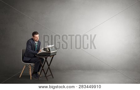 Man working hard on a typewriter in an empty space