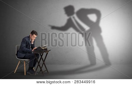 Little man working and a big shadow arguing with him
