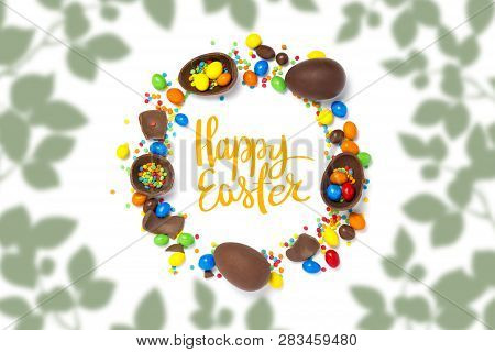 Broken And Whole Chocolate Eggs, Multi-colored Sweets, White Background. Text Happy Easter. Contour 