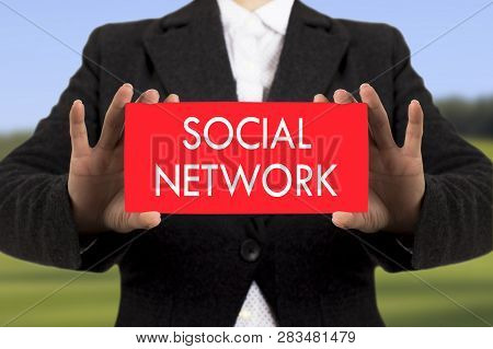 Businesswoman In A Black Jacket Shows A Card With The Inscription Social Network. Selective Focus.